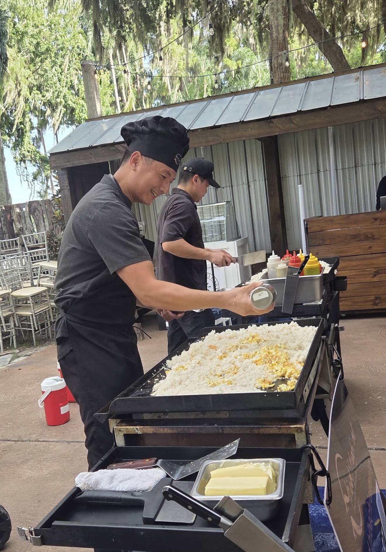 Hibachi chef cooking fried rice on an outdoor flat-top grill at a private event in Middleburg, Florida