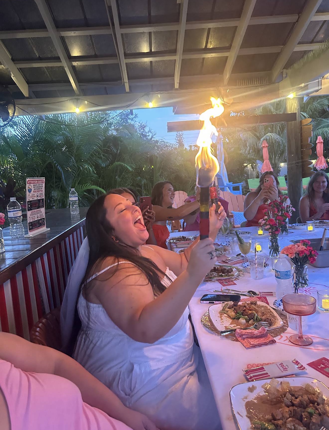 Guests enjoying a hibachi chef fire show at a private outdoor dinner party in Fruit Cove, Florida