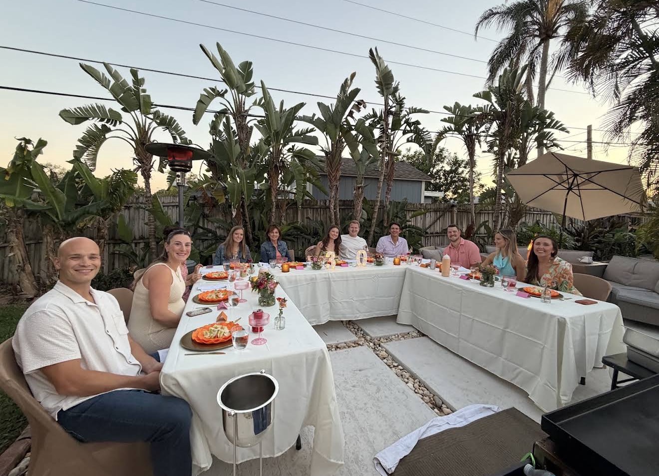 Large group of happy guests enjoying an outdoor hibachi dinner party in a backyard in Celebration, Florida
