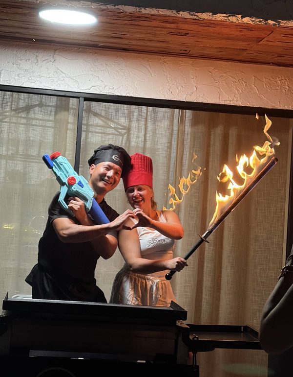 Hibachi chef and a guest posing playfully with a fire torch at a private party in Dunedin, Florida