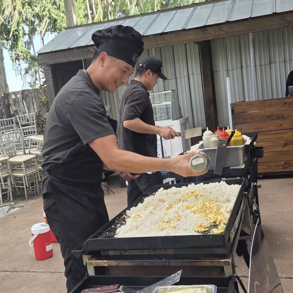 Hibachi chef cooking fried rice on an outdoor flat-top grill at a private event in Dunedin, Florida