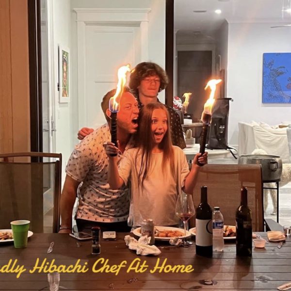 Happy family holding flaming torches together at an indoor hibachi dinner party