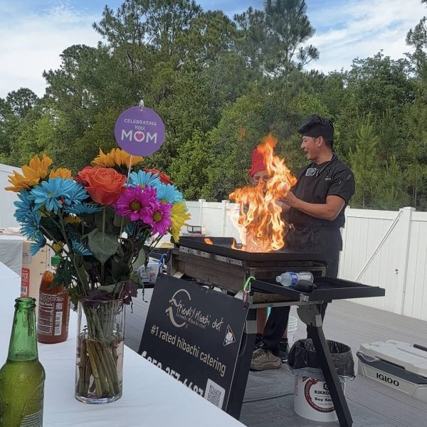 Hibachi chef performing a dramatic fire show at an outdoor Mother's Day celebration in Clearwater Beach, Florida