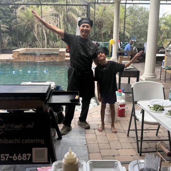 Hibachi chef and a young guest posing by the grill at a poolside backyard party in Riverview, Florida