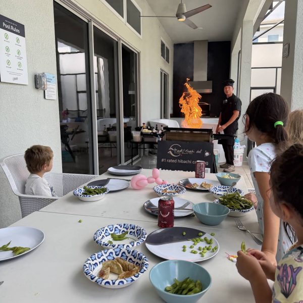 Family with kids watching a hibachi chef fire show during a private dinner at home in Riverview, Florida